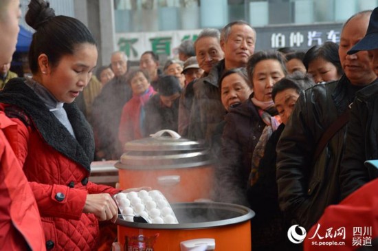 成都沙灣街頭，前來品嘗免費湯圓的市民排起了長龍。王波 攝