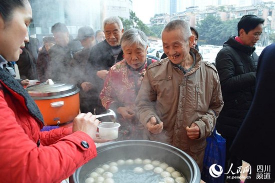成都沙灣街頭，前來品嘗免費湯圓的市民排起了長龍。王波 攝