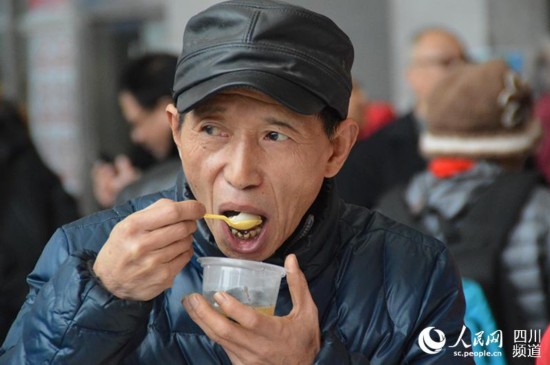市民大口地吃起了免費湯圓。王波 攝