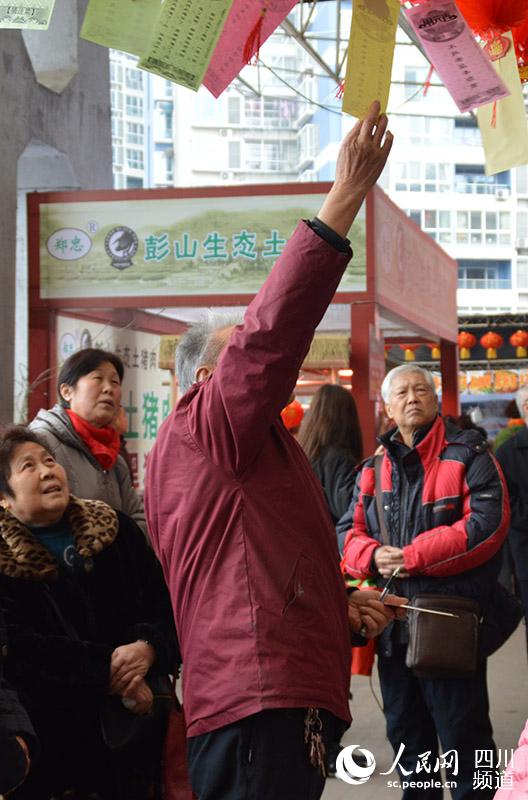元宵節民俗，猜燈謎游戲也引得不少市民駐足。王波 攝