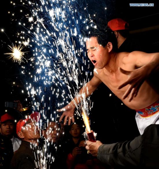 A villager performs 'firework eating' in Huadong Village, Putian City of southeast China's Fujian Province, Feb. 12, 2017.