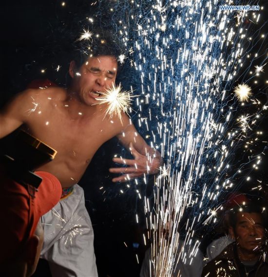 A villager performs 'firework eating' in Huadong Village, Putian City of southeast China's Fujian Province, Feb. 12, 2017. 