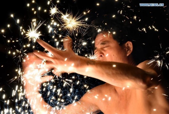 A villager performs 'firework eating' in Huadong Village, Putian City of southeast China's Fujian Province, Feb. 12, 2017.