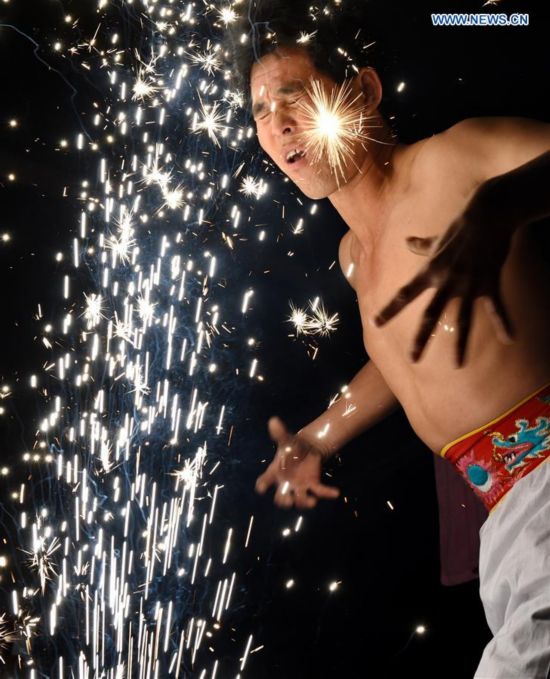 A villager performs 'firework eating' in Huadong Village, Putian City of southeast China's Fujian Province, Feb. 12, 2017.