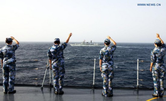 Soldiers on the Jinggangshan dock landing ship wave goodbye to the 14th Escort Taskforce of the Chinese Navy at the Gulf of Aden, Aug. 26, 2013. [Photo: Xinhua]