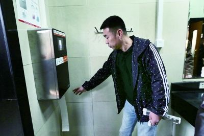 A tourist is using the face detection toilet paper dispenser in Temple of Heaven Park on Mar 18, 2017. [Photo: fawan.com]