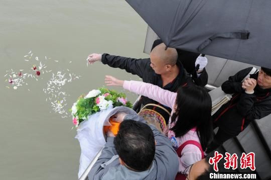 People scatter petals and cremains of their diseased family members into the sea in Fuzhou, southeast China's Fujian province, March 28, 2013. [Photo: Chinanews.com]