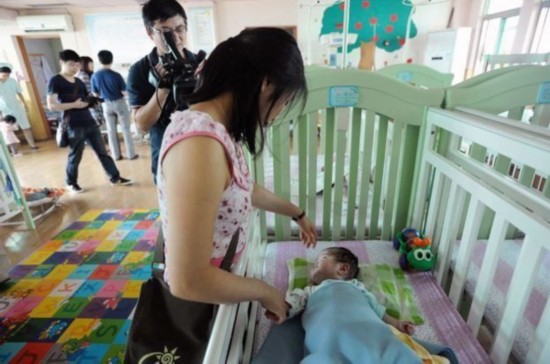 Jenna Cook visits the orphanage where she was taken as a baby in 1992. [Photo: sina.com.cn]