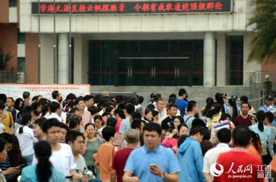 送完孩子进入考场后,家长们还聚集在考点校门口。