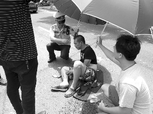 外卖小哥遭遇车祸 无锡城管烈日下为伤者打伞