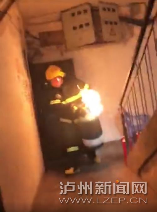消防战士抱着燃烧的气罐冲出楼道 (视频截图)