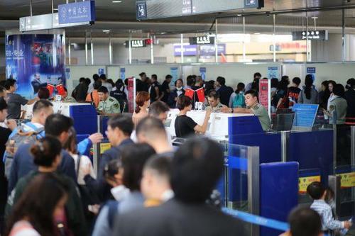 中國僑網9月30日，青島機場邊檢站民警為出境游旅客辦理通關手續。新華社發