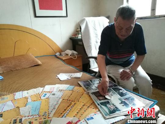 翻着相簿,蔡国基述说着两人跨越海峡的情谊。 钟升 摄