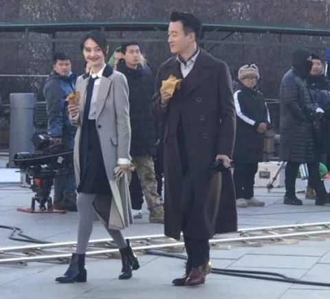 网曝郑爽佟大为街头吃红薯 一袭复古风衣有说