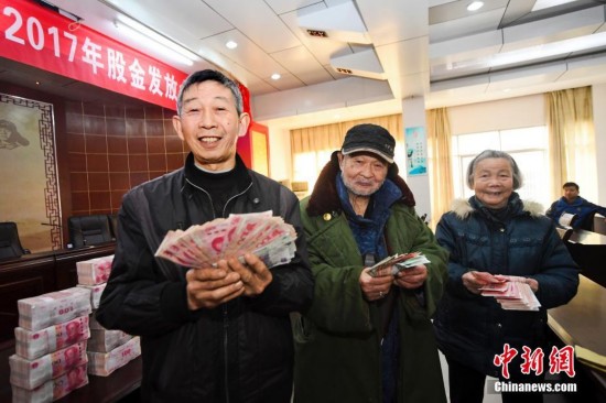 村民代表喜领年终股金红利 怀抱现金喜上眉梢