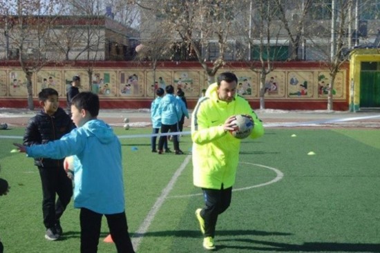 One of the coaches from Football Club Internazionale Milano teaches soccer at Xiongxian No 1 Primary School in North China's Hebei province, Jan 29, 2018. (Photo provided to chinadaily.com.cn)