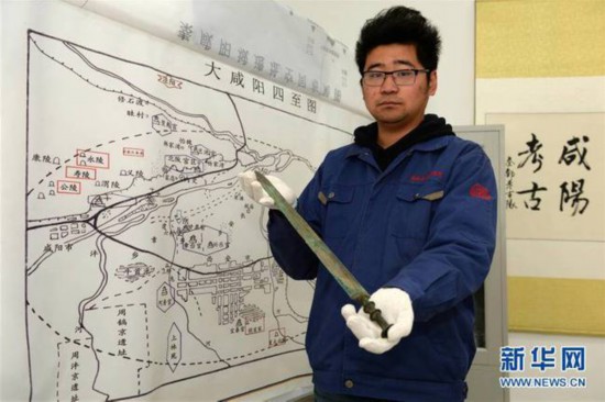 3月16日,陕西省考古研究院助理研究员张杨力铮展示西咸新区空港新城岩村秦人墓葬发掘中发现的铜剑。秦人爱饮酒?2000多年前古人饮用的酒是什么样的?近日,陕西省考古研究院公布了西咸新区空港新城岩村秦人墓葬的发掘结果。这批平民墓葬的时间集中在战国晚期到秦代,尽管多次被盗扰,依然出土了不同材质的文物约260余件,其中引人瞩目的是在一件密封较好的铜壶里,发现了距今2000多年的古酒。新华社记者 李一博 摄