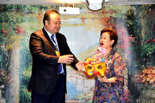 劉奇代表“親情中華”藝術團回贈具有濃郁民族特色的手工縫制的山西布藝老虎。