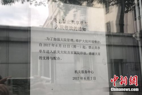 某單位大門貼出的“禁止共享單車入內”通知。中新網 吳濤 攝