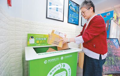 日前,在浙江杭州市西湖区西溪蝶园小区的菜鸟驿站,市民将快递包装