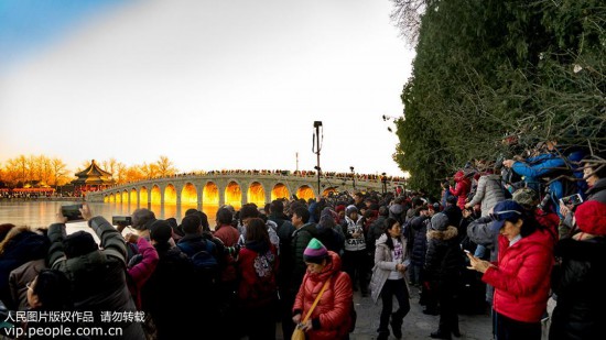 12月18日，北京頤和園，攝影愛好者們在寒冷中耐心等候“金光穿洞”美景。