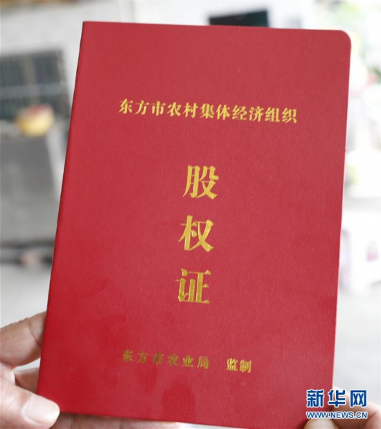图为乐妹村村民领到的农村集体经济组织股权证(12月14日摄).