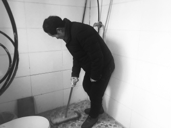 张茂生在自家无害化卫生厕所内打扫卫生.