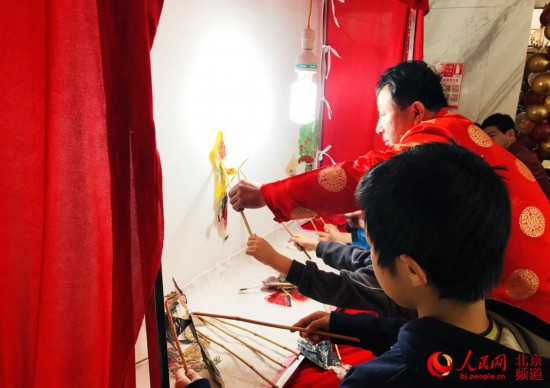 小朋友體驗傳統非遺項目皮影戲，感受傳統年俗。人民網 董兆瑞攝