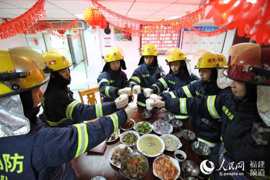 漳州消防特勤大隊一中隊消防指戰員歡聚一堂，吃年夜飯，舉杯共飲。