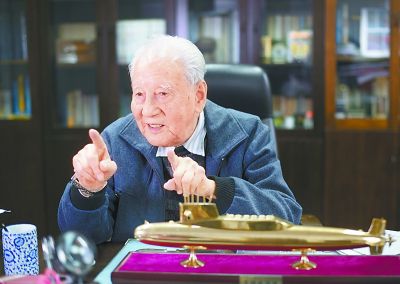 2016年12月20日,黄旭华在办公室内与同事交谈.