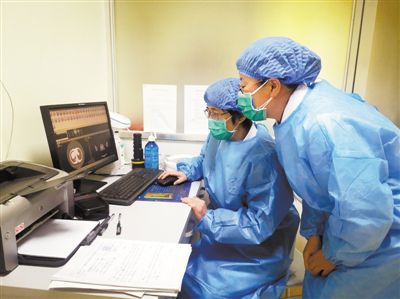 张红（左）与陈爱美（右）正在查看患者CT检查影像 受访者供图