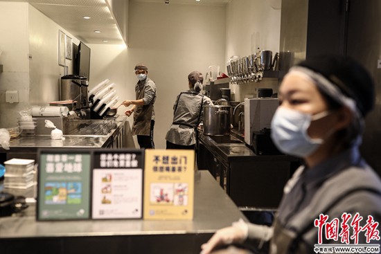 2月22日、湖北省武漢市楚河漢街にあるミルクティー店で、最前線で奮闘する医療スタッフに送り届けるためにミルクティーを作る24歳の店員の陳世昌さん（写真左、撮影・趙迪）。