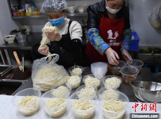 「重慶小麺の未調理食材セット」の配達準備をする重慶のあるレストランのスタッフ（撮影・周毅）。