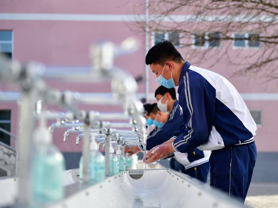 3月13日，青海省海東市互助土族自治縣民族中學的學生在進入食堂用餐前洗手。新華社記者 張龍 攝