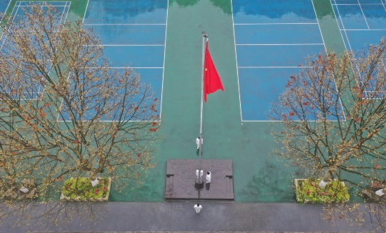 3月16日，貴陽市第六中學國旗班學生在操場上升旗，其余同學則在教室內參加升旗儀式。新華社記者 歐東衢 攝