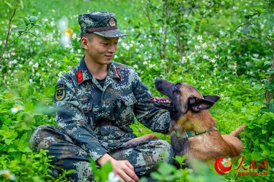 離開墓園后，馴導員孔德鑫安撫著軍犬“拉克”。