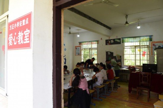 7月22日，在樅陽縣橫埠鎮方正小學安置點，小朋友們在“愛心教室”裡看書寫作業。