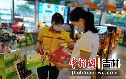 昆侖好客便利店員工向顧客介紹“鶴勝恏谷”品牌農副產品 李林燕/攝