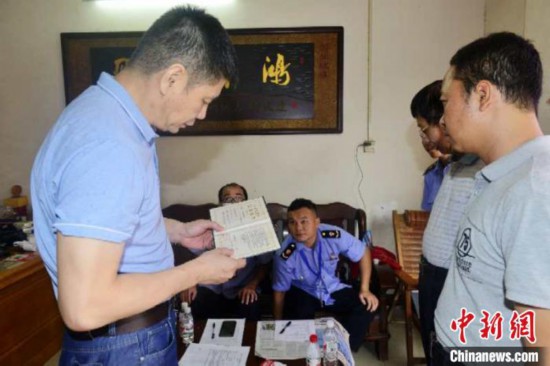 圖為廣西市場監管局工作人員查驗經營戶營業執照。廣西市場監管局供圖