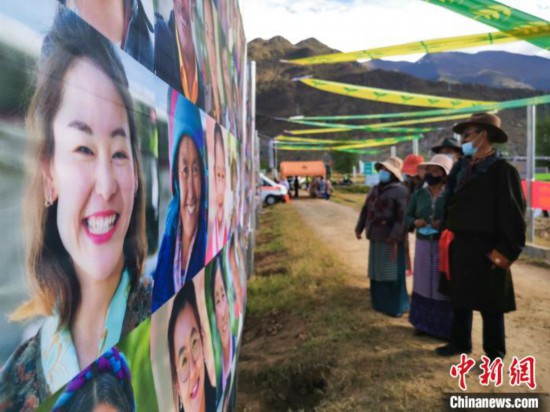 圖為當地民眾在觀看展板上的笑臉。　張偉 攝