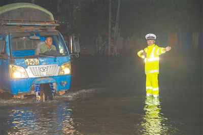 萬寧交警在積水的路上堅守崗位指揮交通