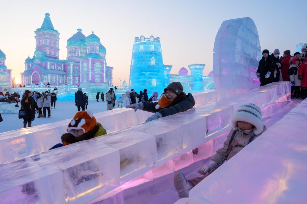 游客在哈尔滨冰雪大世界园区内体验冰滑梯。新华社发 游客在哈尔滨冰雪大世界园区内体验冰滑梯。新华社发