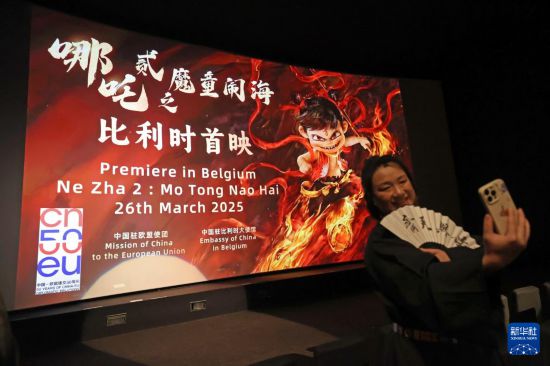 3月26日，在比利时布鲁塞尔，观众在《哪吒之魔童闹海》首映活动上拍照。新华社记者 赵丁喆 摄