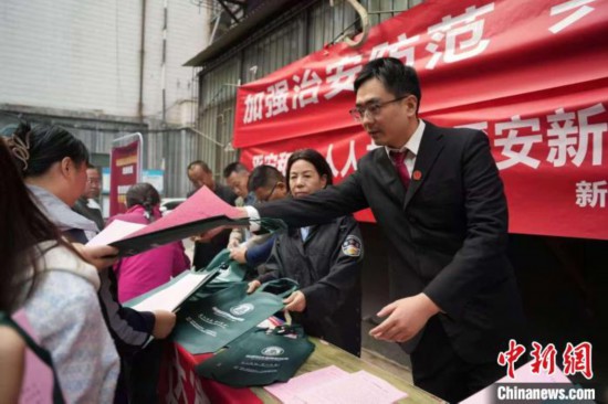  图为西安中院青年法官曲旺旺(右一)在社区进行普法宣传活动。(西安中院供图)