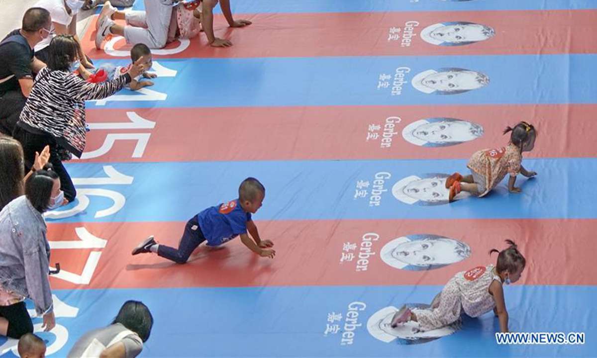 Babies participate in a baby crawling contest at a shopping center in Daxing District, Beijing, capital of China, Sept. 13, 2020. (Xinhua/Li Xin)