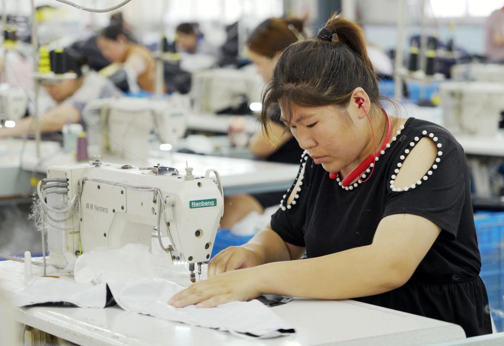 5月20日,村民在李寨村服装加工厂内忙碌。河南省周口市沈丘县冯营镇李寨村地处豫东平原。近年来,乘着脱贫攻坚与乡村振兴政策的东风,李寨村积极探索产业发展模式,通过“龙头企业+村集体经济+农户”的方式,逐渐发展形成肉牛养殖、设施农业、服装加工、康养民宿等产业,以产业振兴助力乡村振兴。新华社记者 李嘉南 摄 5月20日,村民在李寨村服装加工厂内忙碌。河南省周口市沈丘县冯营镇李寨村地处豫东平原。近年来,乘着脱贫攻坚与乡村振兴政策的东风,李寨村积极探索产业发展模式,通过“龙头企业+村集体经济+农户”的方式,逐渐发展形成肉牛养殖、设施农业、服装加工、康养民宿等产业,以产业振兴助力乡村振兴。新华社记者 李嘉南 摄