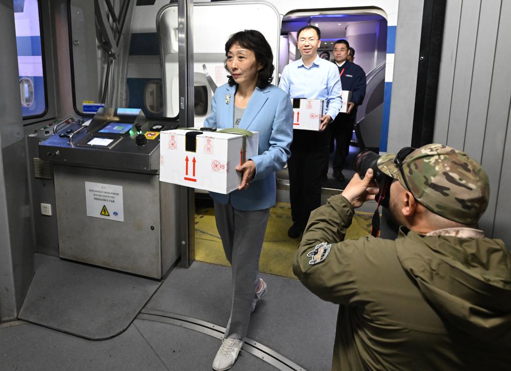 护送文物归国的工作人员手捧装载着子弹库帛书的保护箱走出客机(2025年5月18日摄)。新华社记者 李贺 摄 护送文物归国的工作人员手捧装载着子弹库帛书的保护箱走出客机(2025年5月18日摄)。新华社记者 李贺 摄
