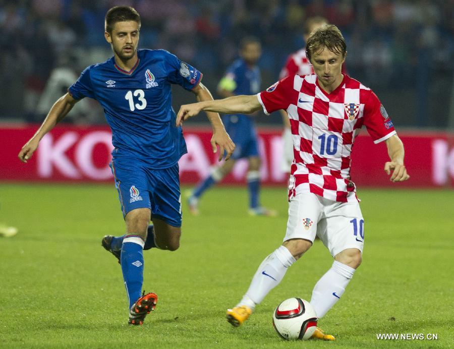 Luka Modric (R) of Croatia vies with Dmitri Nazarov of Azerbaijan during their UEFA Euro 2016 qualifying match at Gradski vrt Stadium in Osijek, Croatia, Oct. 13, 2014. 