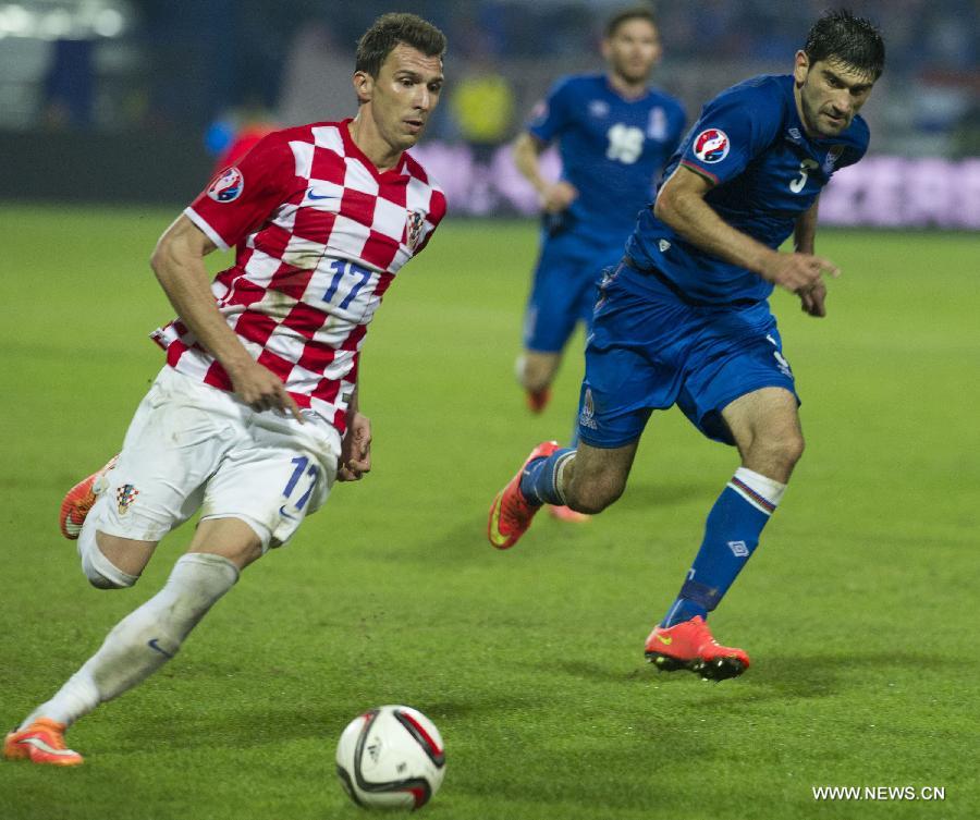 Mario Mandzukic (L) of Croatia vies with Rasim Ramaldanov of Azerbaijan during their UEFA Euro 2016 qualifying match at Gradski vrt Stadium in Osijek, Croatia, Oct. 13, 2014. 