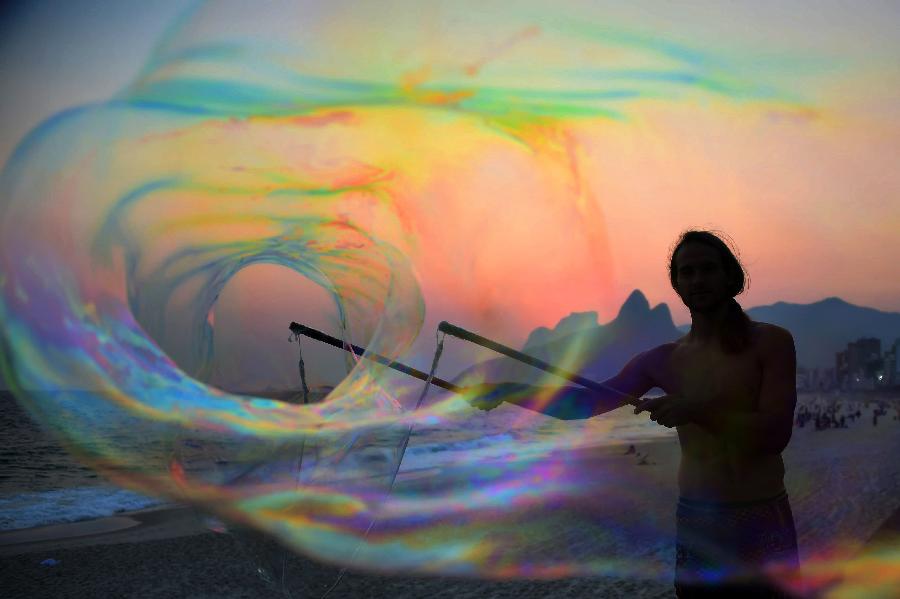 A tourist plays with bubbles at sunset, on Ipanema beach in Rio de Janeiro, October 13, 2014. 